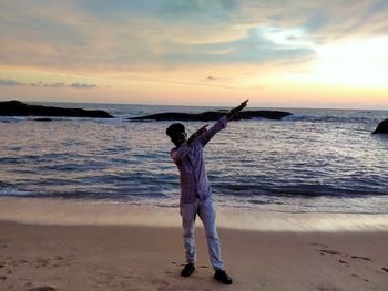 Full length of man standing at beach during sunset