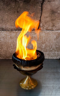 Close-up of burning candles on wooden wall