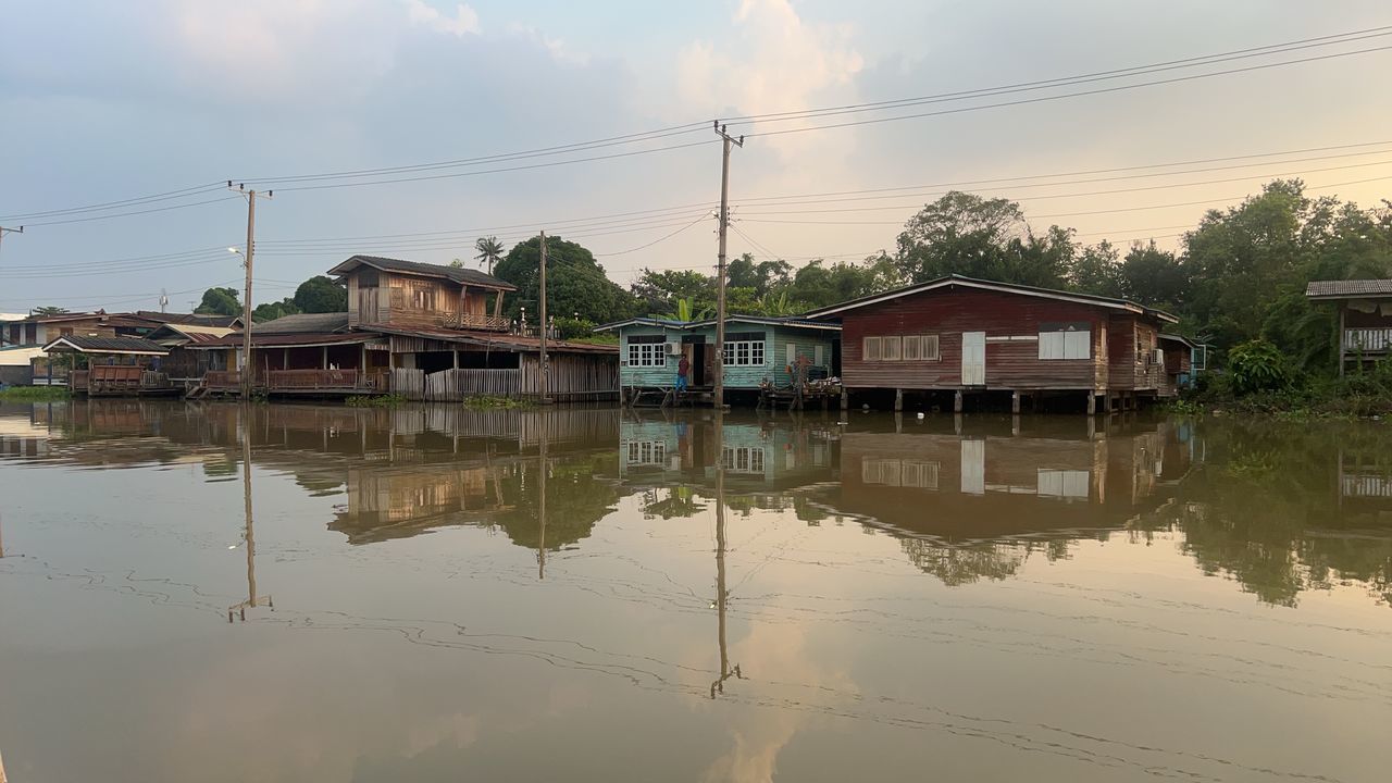 water, architecture, reflection, built structure, building, house, building exterior, nature, sky, residential district, river, stilt house, cloud, landscape, environment, no people, tree, outdoors, reflection lake, tranquility, rural scene, cable, beauty in nature, business finance and industry, travel destinations, industry, village, city, electricity, travel