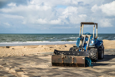 Deck chairs on beach against sky