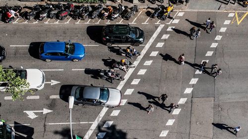 High angle view of people and vehicles on city street