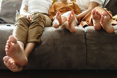 Low section of woman lying on bed at home