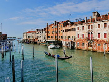 Boats in canal by buildings in city