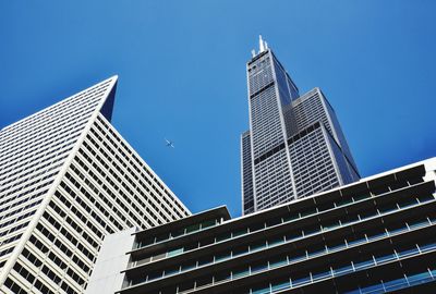 Low angle view of skyscrapers against clear blue sky