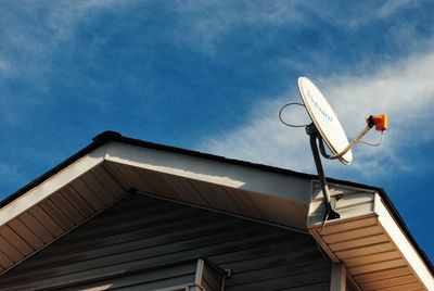 Low angle view of satellite dish on house against sky