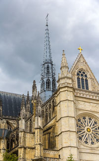 Low angle view of building against cloudy sky