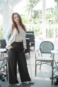 Portrait of young woman standing on table