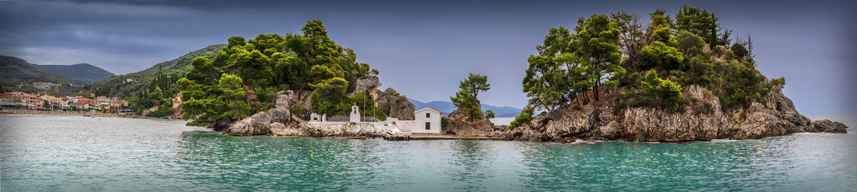 Panoramic shot of sea and buildings against sky