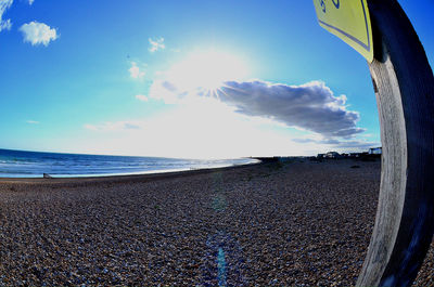 Scenic view of beach against cloudy sky