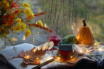 Autumn decor with flowers, open book and cup of tea