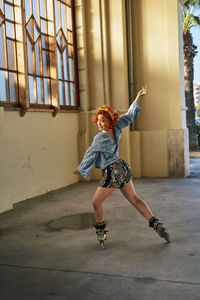 Young alternative redhead girl dancing in roller skates