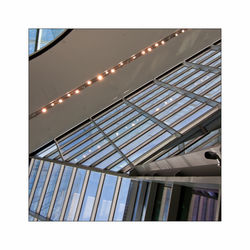 Low angle view of illuminated building against sky seen through glass window