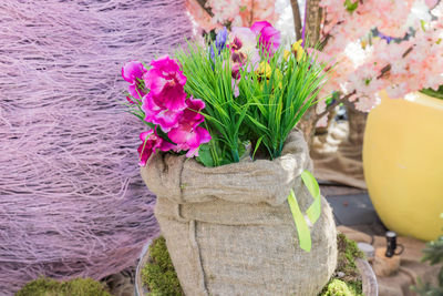 Close-up of pink flower pot on tree trunk