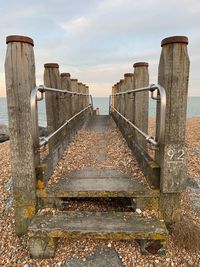 Staircase leading towards sea against sky