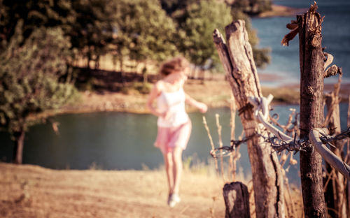 Full length of shirtless young woman against trees