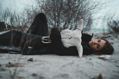 Portrait of woman lying down on snow land