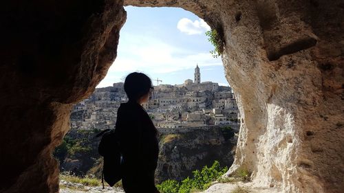 Rear view of man standing on rock looking at view