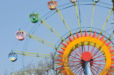 Low angle view of ferris wheel against clear blue sky