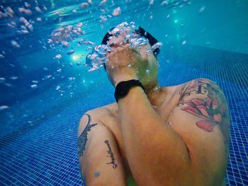 Low section of woman swimming in pool