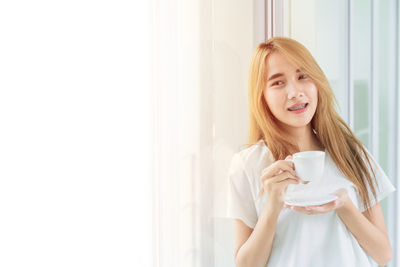 Young woman drinking coffee cup at home
