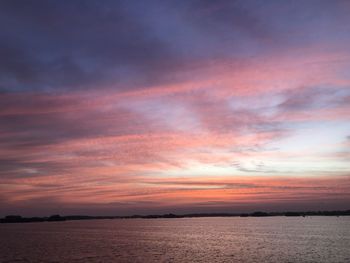 Scenic view of sea against dramatic sky during sunset