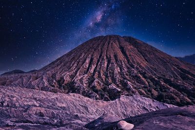 Scenic view of snowcapped mountains against sky at night