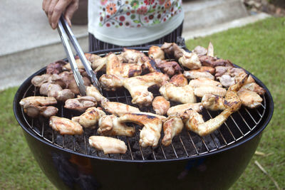 Close-up of person preparing food on barbecue grill