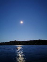 Scenic view of sea against clear blue sky at night