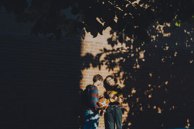 People standing by tree in city