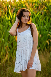 Young woman standing against plants