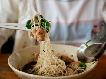 Close-up of hand holding rice in bowl