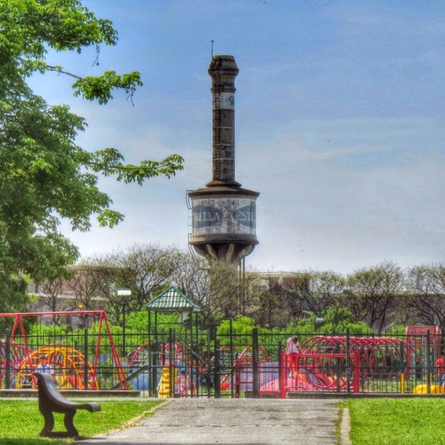 tree, built structure, architecture, sky, building exterior, tower, fence, protection, metal, park - man made space, safety, railing, grass, famous place, travel destinations, day, security, growth, tourism, metallic