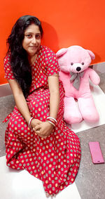 Portrait of a smiling young woman with toy