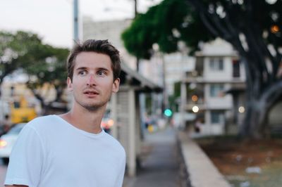 Close-up young man looking away standing on street