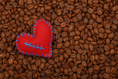 Close-up of heart shape decoration over roasted coffee beans