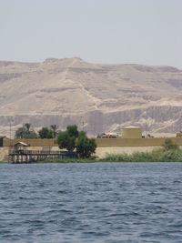 Scenic view of lake by buildings against sky