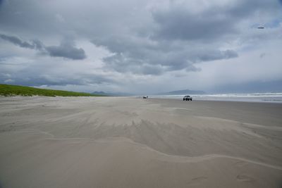 View of beach against cloudy sky