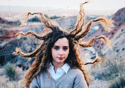 Portrait of smiling young woman against tree