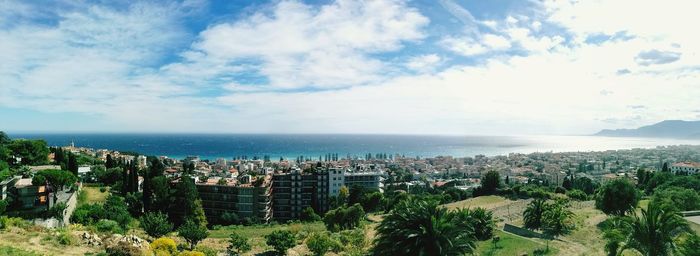 Panoramic view of sea and cityscape against sky