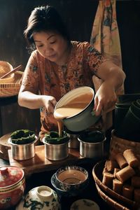A peranakan lady is making nian gao for lunar new year