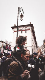 People on street against sky in city