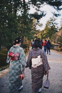 Rear view of woman wearing kimono walking on road