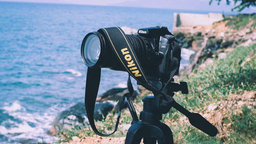 Close-up of camera with bicycle on shore