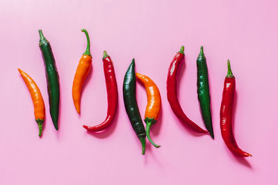 High angle view of chili peppers over yellow background