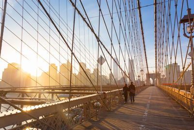 Man on footbridge against sky