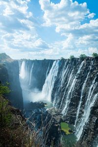 Scenic view of waterfall against sky