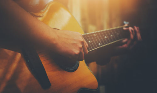 Midsection of man playing guitar