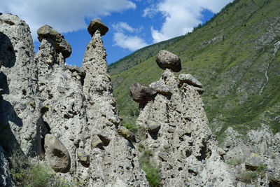 Low angle view of rocks on mountain against sky