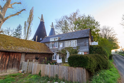 House amidst trees and buildings against sky