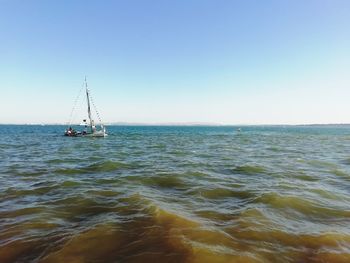 Sailboat in sea against clear sky